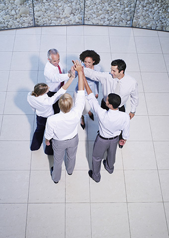 Leadership team joining hands in a display of team-building unity